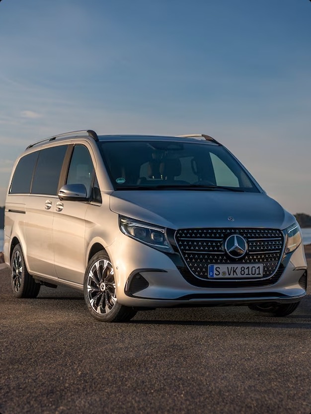 Un elegante furgone Mercedes-Benz in colore argento, parcheggiato su una strada panoramica. Il design moderno include griglia frontale caratteristica e cerchi in lega lucida.